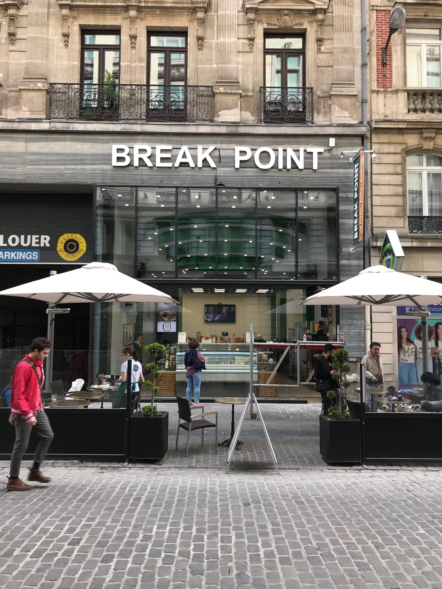 Devanture vitrée d'un commerce avec sa terrasse en activité