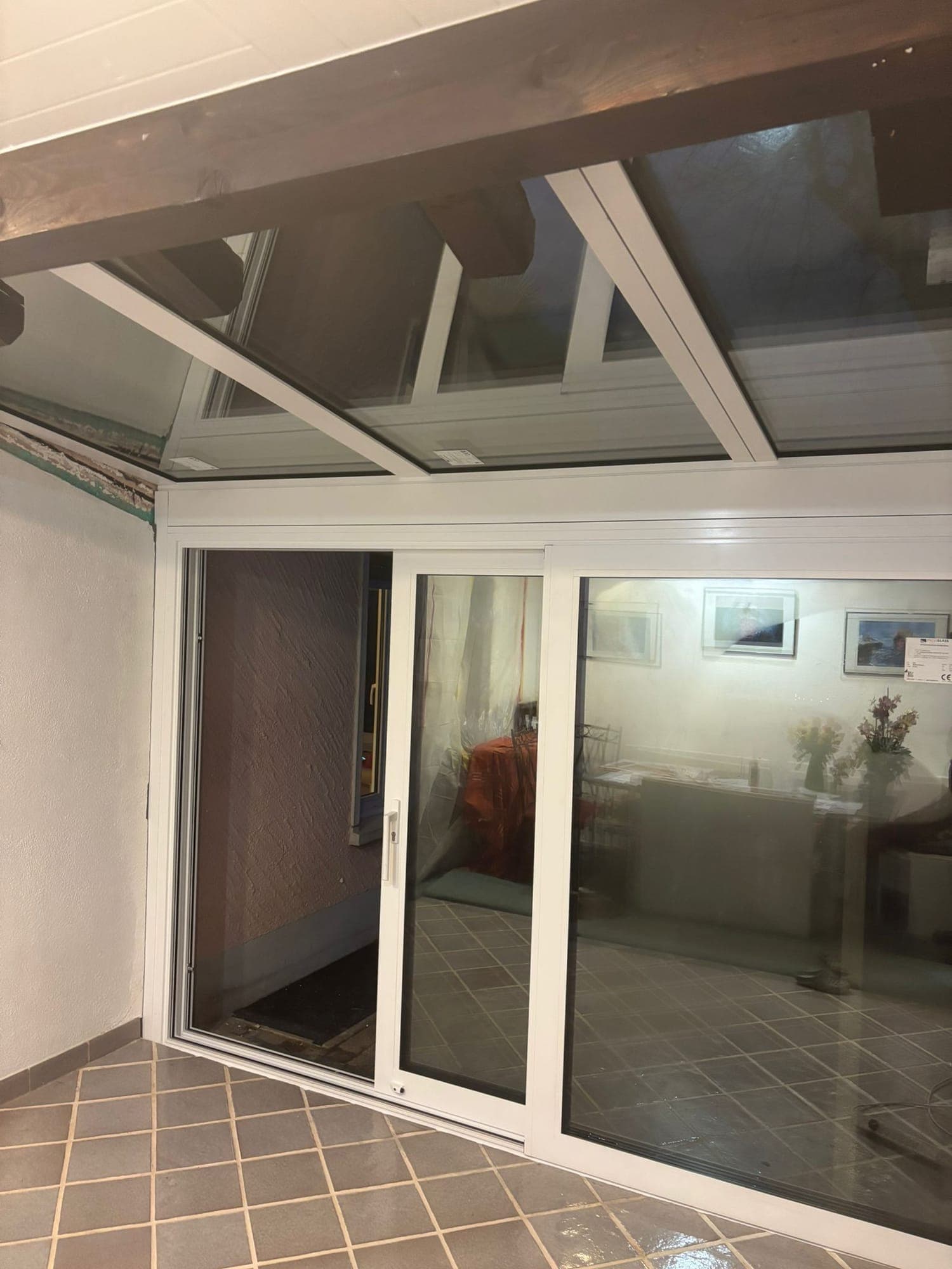 Intérieur de la véranda avec toiture vitrée et baie coulissante